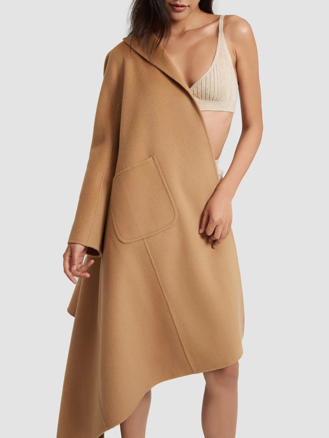 Woman wearing a beige coat over a beige top on a white background